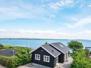 a small house on the shore of a body of water at Panoramic Retreat by Water - By Traum Ferienwohnungen in Børkop