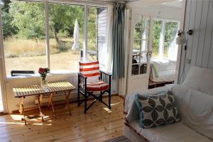a living room with a bed and a table and chairs at 12255-Sjaellands-Odde-Klokkelyngvej-5 in Tjørneholm
