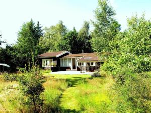 a house in the middle of a field with trees at 12255-Sjaellands-Odde-Klokkelyngvej-5 in Tjørneholm
