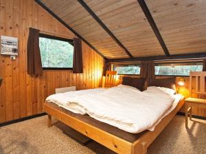 a bedroom with a large bed in a wooden room at Holiday Home Escape in Scenic Rodby in Rødby