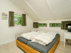 吉利勒杰4 person holiday home in Gilleleje-By Traum的有两扇窗户的房间里有一张大床