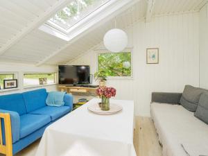 吉利勒杰4 person holiday home in Gilleleje-By Traum的客厅里有一张蓝色的沙发和一张桌子