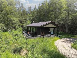 a small cabin in the woods next to a dirt road at 4 person holiday home in Læsø in Læsø +15 photos