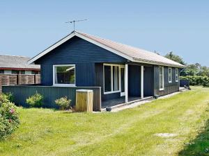 a blue house with a yard in front of it at 6 person holiday home in Løkken-By Traum in Løkken +30 photos