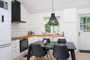 a kitchen with a black table and chairs at 14235-Grevinge-Askebjerggardsvej-20 in Grevinge