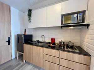 a kitchen with a stove and a microwave at Tu espacio acogedor en el Centro Internacional in Bogotá