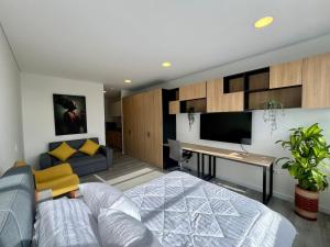 a living room with a bed and a desk at Tu espacio acogedor en el Centro Internacional in Bogotá