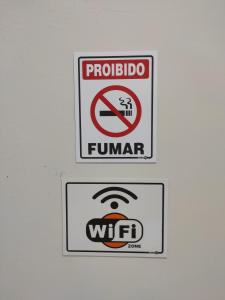 two signs on the wall of a bathroom at Apartamento Nami 2 in Cacoal +2 photos