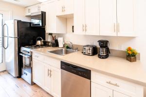 a kitchen with white cabinets and a stainless steel refrigerator at Modern 1-Bedromm Loft In Hollywood With Viwe of Hollywood Sign in Los Angeles