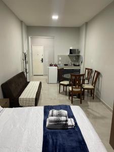 a bedroom with a bed and a living room and a kitchen at Flat Centro Rio Av Presidente Vargas x Uruguaiana - Vista panorâmica do Cristo & Metrô in Rio de Janeiro