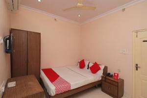 a bedroom with a bed with red pillows at Hotel O Steel City in Jāmul