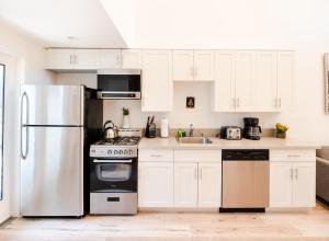 a kitchen with white cabinets and a stainless steel refrigerator at Modern 1-Bedromm Loft In Hollywood With Viwe of Hollywood Sign in Los Angeles +9 photos