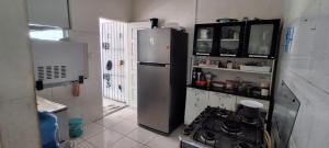 a kitchen with a refrigerator and a stove in it at Casa Cop 30 em condomínio in Ananindeua