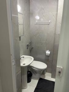 a bathroom with a white toilet and a sink at Flat Centro Rio Av Presidente Vargas x Uruguaiana - Vista panorâmica do Cristo & Metrô in Rio de Janeiro +20 photos