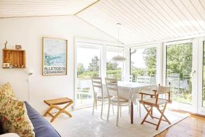 a living room with a dining room table and chairs at 15524-Farevejle-Lynghoj-5 in Fårevejle