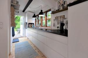 a kitchen with white cabinets and black counter tops at 16664-Farevejle-Klinteborgvej-7 in Fårevejle