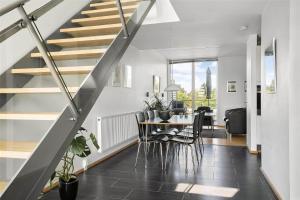 comedor y sala de estar con mesa y escaleras en 0427-Romo-Nordre-Havnevej-58, en Havneby