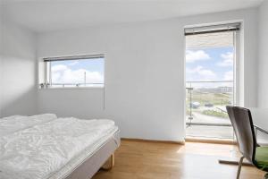 Un dormitorio blanco con una cama y una ventana. en 0427-Romo-Nordre-Havnevej-58, en Havneby