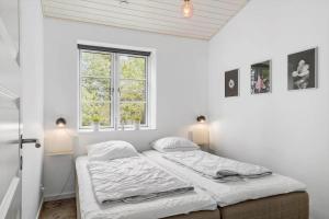 two beds in a white room with two windows at 0003-Romo-Vestervej-39 in Toftum