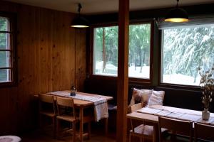 a dining room with two tables and two windows at Kitsune Lodge Myoko Japan-self contained in Myoko
