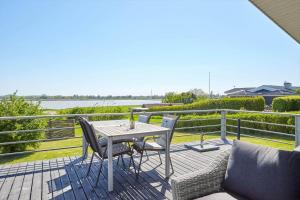 a table and chairs on a deck with a view of the water at 14249-Grevinge-Strandmosen-4 in Grevinge