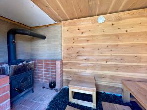 a room with a fireplace and a wooden wall at Sauna and BBQ Motosuka Beach Amansuka-サウナ&BBQ 本須賀ビーチAmansuka in Sammu