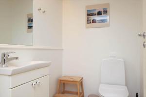 a white bathroom with a sink and a toilet at 11206-Nykobing-Sj-Havnevej-87-st-th in Nykøbing Sjælland +19 photos