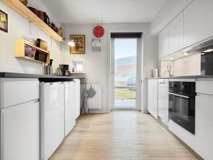 Sønderbyにある0458-Romo-Vestergade-129-App-91の白いキャビネットと大きな窓のあるキッチン