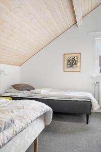 Sønderbyにある0458-Romo-Vestergade-129-App-91のベッドが2つあり、天井が木製の寝室