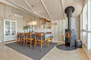 a kitchen and dining room with a wood stove at 8104-Ronde-Valmuevej-19 in Rønde