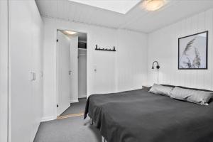 a bedroom with a bed in a white room at 0351-Romo-Regnspoven-8 in Mølby