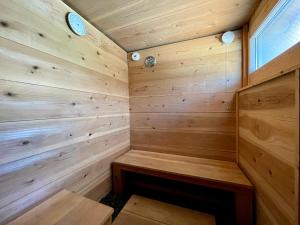 a wooden sauna with a bench in the corner at Sauna and BBQ Motosuka Beach Amansuka-サウナ&BBQ 本須賀ビーチAmansuka in Sammu