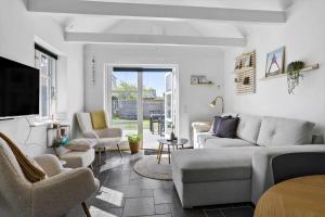 a living room with a couch and chairs and a tv at LK1929-Lokken-Norgesvej-27-A in Løkken +3 photos