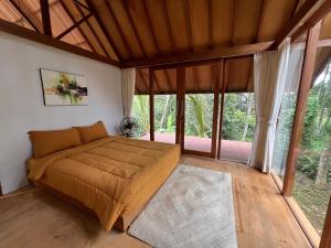 une chambre avec un lit dans une pièce avec des fenêtres dans l'établissement Pondok Mawas, à Ubud
