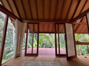 une chambre avec une grande porte en verre dans une maison dans l'établissement Pondok Mawas, à Ubud