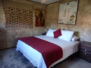 a bedroom with a large bed with red and white sheets at Texas Limache in Limache +23 photos