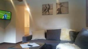 salon z kanapą i telewizorem w obiekcie Bhome Gästehaus b&b / Apartments w mieście Neukirchen am Großvenediger