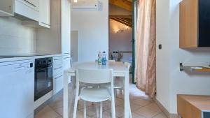 a kitchen with a white table and two white chairs at App 19 Elegante Mansarda con Terrazzo e Parcheggio in Monza +10 photos