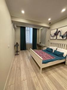 a bedroom with a large bed in a room at Studio apartment in Dushanbe