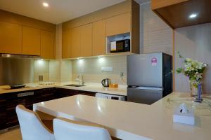 a kitchen with a white counter top and a refrigerator at R&F Princess Cove JB By SaffronCasa JB in Johor Bahru