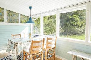 a dining room with a table and chairs and windows at 11817-Nykobing-Sj-Solystgardsvej-16 in Nyrup +15 photos