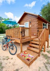 a bike parked next to a cabin with an umbrella at Luxury Cabin #11 in Ocala