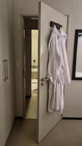 a bathroom door with white towels hanging on it at 391 at SoHo in Sandton