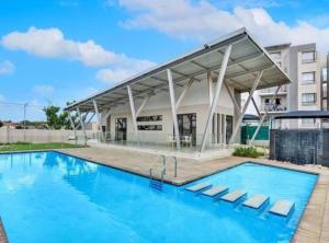 a large swimming pool with a building in the background at 391 at SoHo in Sandton