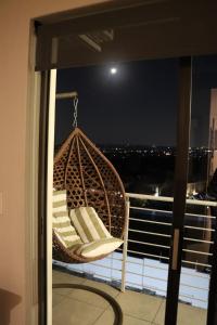a hammock on a balcony with a view of the city at 391 at SoHo in Sandton