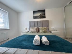 Un dormitorio con una cama grande con dos almohadas. en Alvea Living, en Bushbury 17 fotos más