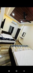 a room with three beds and a ceiling at Shree nidhi comfort stay MAHAKAL ki krupa ujjain in Ujjain