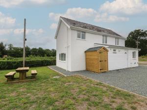 a white building with a shed and a bench at Glandwr House in Llandrindod Wells