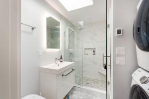 a white bathroom with a shower and a sink at Northern Stay in North Vancouver +17 photos