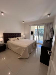 a bedroom with a large bed and a balcony at Green park resort and spa Vacation Club in Punta del Este